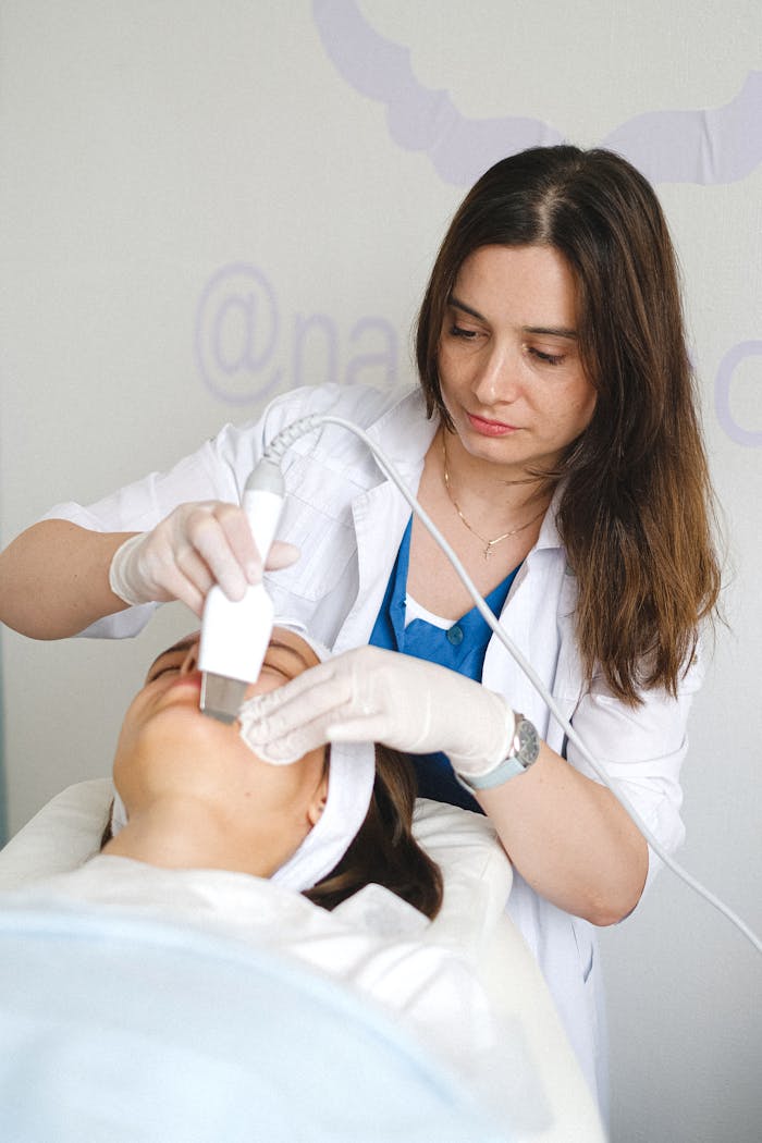 A beautician performing an ultrasonic facial treatment on a client in a professional clinic.